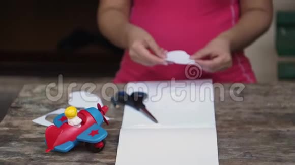 那个女人从纸上剪下一朵云把纸屑放在一边视频的预览图