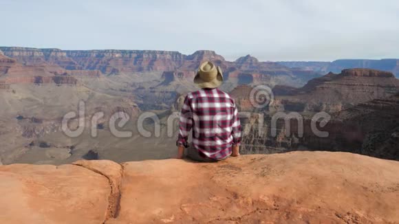 独自一人坐在深渊边缘观看大峡谷的奇妙景色视频的预览图