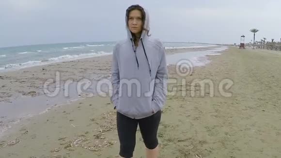 穿着运动服装的沮丧女性在海滩上散步想着分手视频的预览图