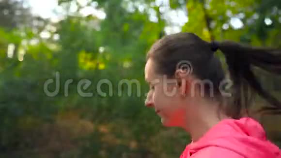 近距离的女人穿过一个秋天的公园看着她的跑步伙伴视频的预览图