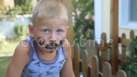 孩子吃冰淇淋男孩用食物弄脏了他的脸孩子吃的是黑华夫饼冰淇淋视频的预览图