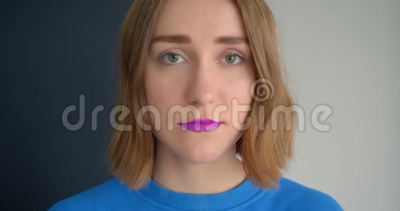 年轻的短毛女性的特写镜头她涂着紫色口红看着相机的背景视频的预览图