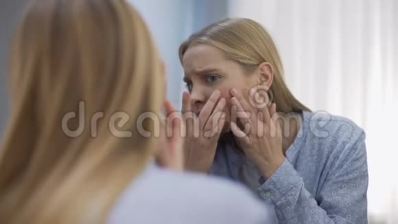 女学生伤心地看着镜子里的脸年轻时的困难视频的预览图