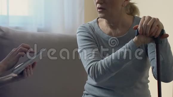 医生在平板电脑上保存电子病历在家检查老妇人视频的预览图