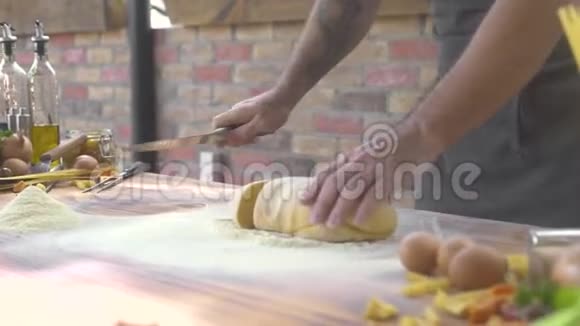 厨师制作面团在食物背景下烹饪意大利面男性手在木板上捏面团视频的预览图
