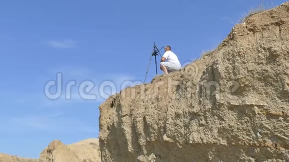 录像员用三脚架上的摄像机拍摄海岸视频的预览图