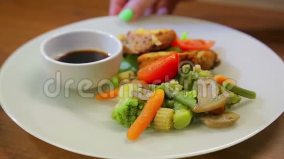 烤火鸡用五颜六色的蔬菜和酱油放在白色盘子里视频的预览图