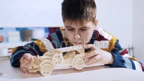 一个男孩从一个木制的三维拼图中构造了一辆车视频的预览图