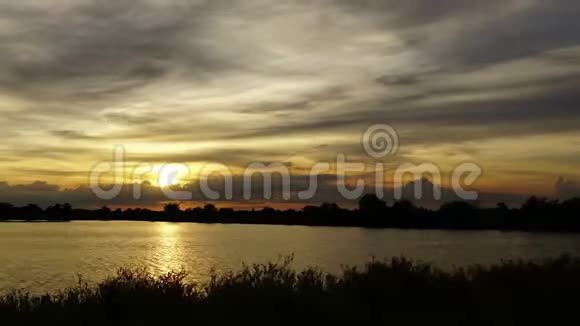 时光流逝夕阳在移动的云后在沼泽上方发出美丽的金光视频的预览图