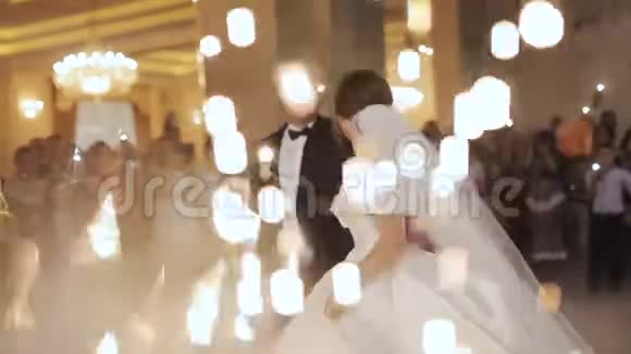 美丽的新娘和新郎在婚礼上跳舞第一支舞被五彩纸屑笼罩视频的预览图