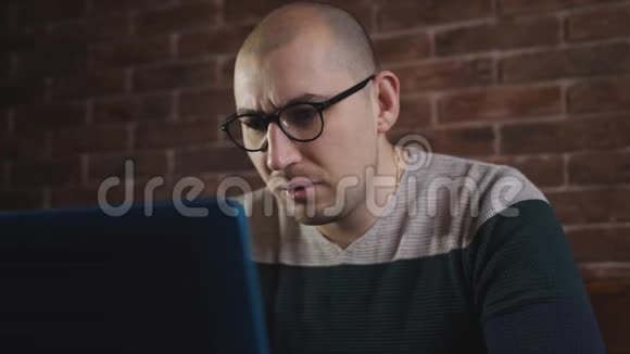 热情的男人带着眼镜在办公室里用笔记本电脑工作一位男性作家正在笔记本电脑键盘上打字特写视频的预览图