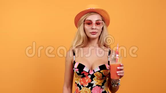 特写一幅美丽火辣的女人喝着热带鸡尾酒的肖像视频的预览图