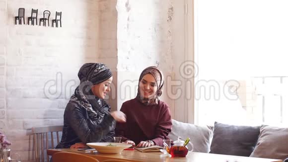 两个年轻的穆斯林商人坐在咖啡馆里商务午餐视频的预览图