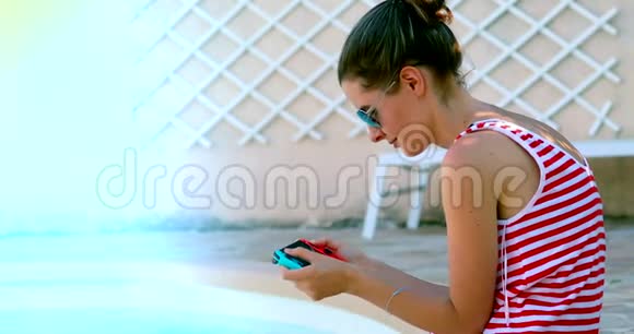 年轻女子在便携式游戏控制台玩游戏视频的预览图