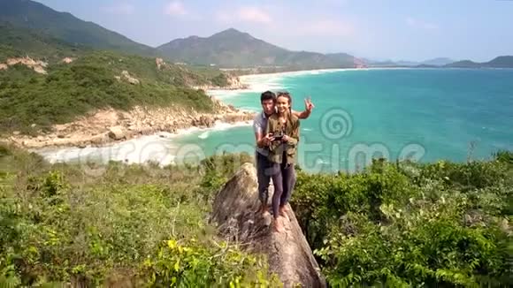 女孩站在高高的悬崖上对抗海景视频的预览图