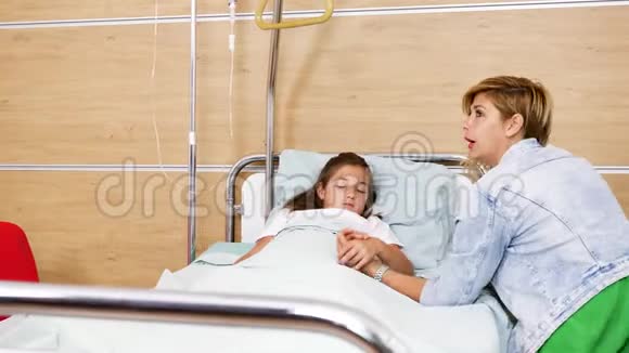 母亲和生病的女儿躺在医院的床上视频的预览图