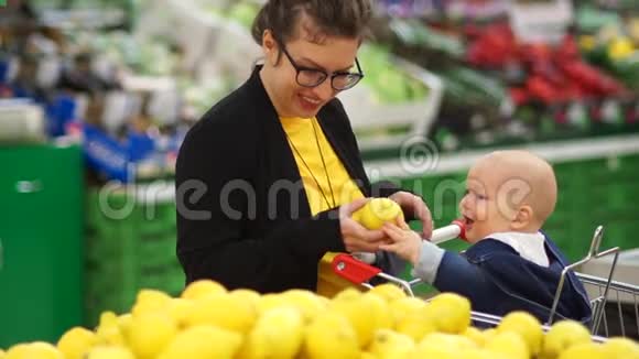 年轻的母亲带着宝贝女儿在超市购物孩子把一个没洗过的柠檬塞进嘴里女人这样做视频的预览图