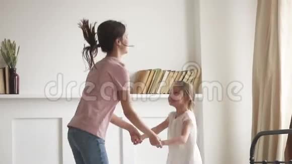 活泼的妈妈牵着女儿的手跳在床上视频的预览图