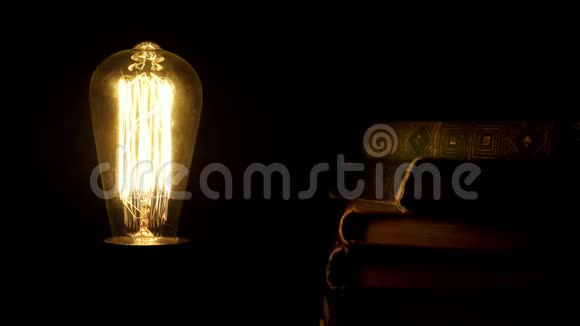 古老风格的复古灯泡闪烁在一堆老式书籍附近视频的预览图