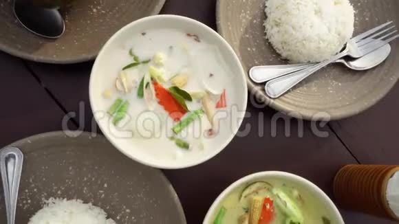 餐桌上有传统的亚洲美食正宗泰国菜咖喱汤哈汤和米饭视频的预览图