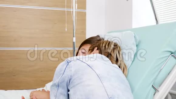 母亲睡在病床上她生病的女儿旁边视频的预览图