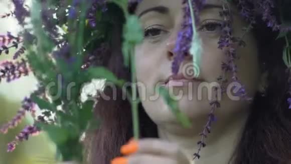 慢动作特写美丽的女孩在田野的头上有一个呼吸向日葵的花手里拿着颜色视频的预览图