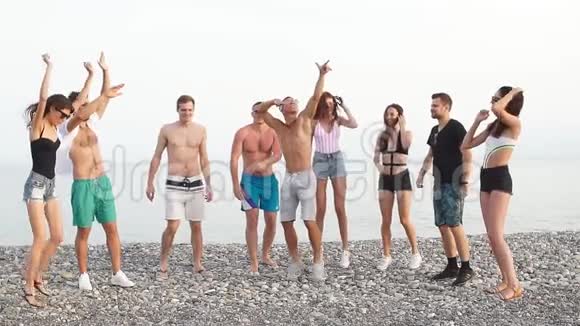 朋友们在日落阳光下在沙滩上跳舞玩得开心享受视频的预览图