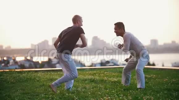 两个强壮的男人展示了夏天在草地上摔跤的元素视频的预览图