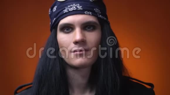 年轻的摇滚歌手化妆长发和头巾在他的头上关闭视频的预览图