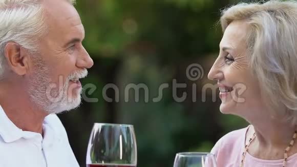 年老的妻子和丈夫享受时光喝酒对着镜头微笑结婚视频的预览图