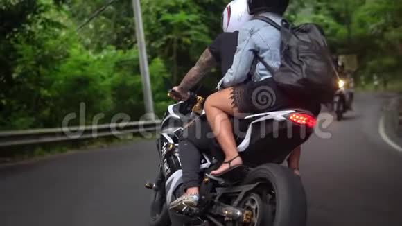 人们骑摩托车在热带农村公路上行驶年轻夫妇有路可走视频的预览图