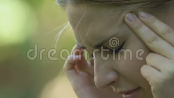 年轻女性头痛男性呼叫公园急救服务视频的预览图