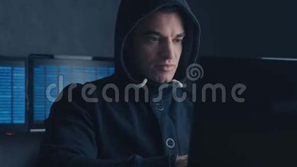 网络犯罪概念一个被通缉的黑客在黑暗的办公室里用电脑视频的预览图