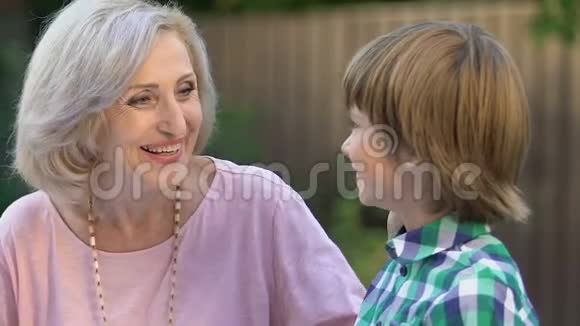 快乐的奶奶和小男孩说话对着镜头微笑幸福的家庭视频的预览图