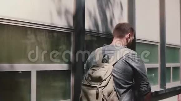 快乐成功英俊的欧洲男人背着背包走在阴凉的夏天纽约街头喝咖啡视频的预览图