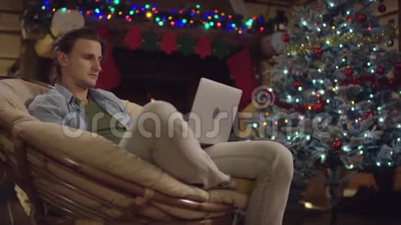 圣诞夜年轻人用笔记本上网视频的预览图