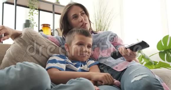 母亲和儿子在家看电视视频的预览图