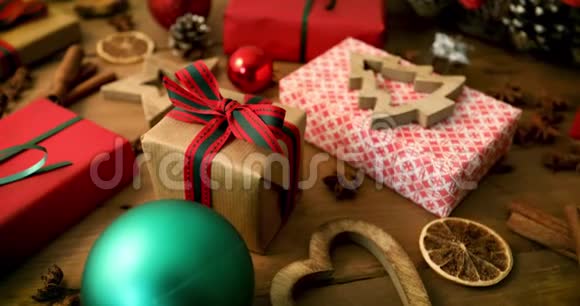 木制桌子上包装的圣诞礼物和装饰品视频的预览图