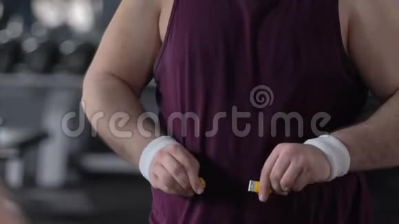 快乐胖子在健身房用胶带测量腹部减肥成就结果视频的预览图