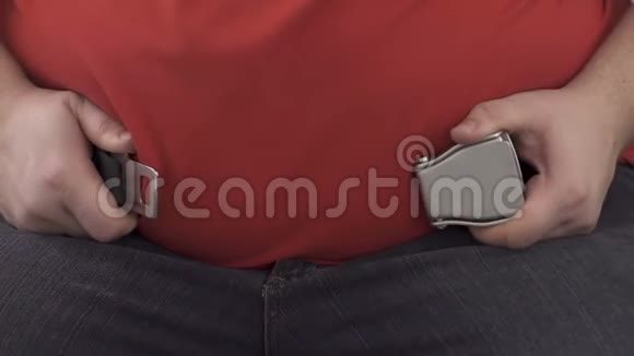 胖乎乎的男人几乎不把安全带系在巨大的腹部上这是预防的手段视频的预览图