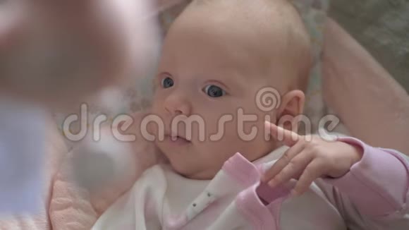 可爱冷静的女婴看着头上的玩具视频的预览图
