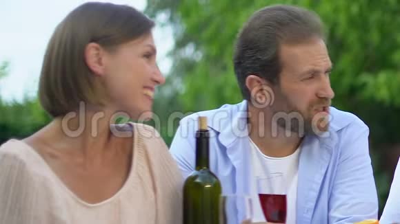 快乐的年轻夫妇和年长夫妇喝酒聊天周末和父母在一起视频的预览图