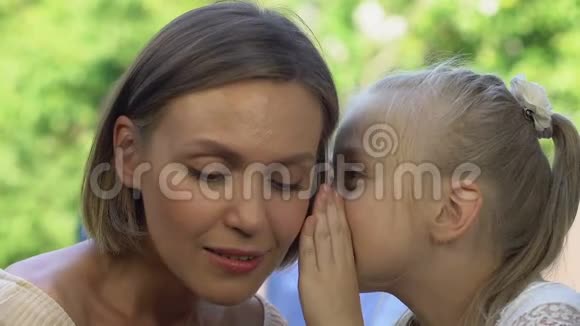 漂亮的小女孩和微笑的妈妈分享秘密信任的家庭关系视频的预览图