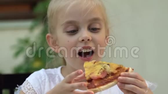 可爱的小女孩吃新鲜美味的披萨快乐的童年周末视频的预览图