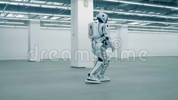 高大的人形机器人正沿着一个空的仓库单元行走视频的预览图