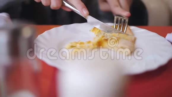 女人的手在咖啡馆的盘子里切了一片比萨饼视频的预览图