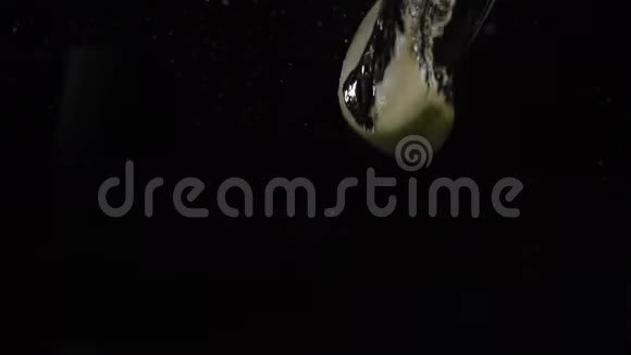 慢动作镜头一片片绿苹果落在水中漂浮黑色背景食物视频视频的预览图