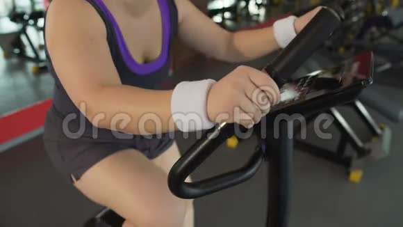 肥胖的女士骑着固定的自行车呼吸困难运动视频的预览图