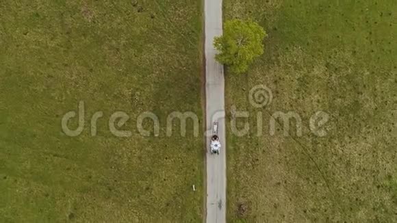马车在一条小路上小路上围绕着大自然空中观景视频的预览图