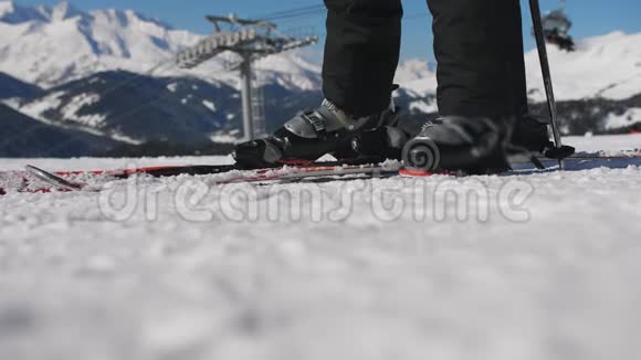 滑雪场的女滑雪者从滑雪场解开滑雪靴手拿着滑雪板离开特写视频的预览图